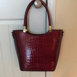 Crimson bag with light sheen looks Brahmin...
